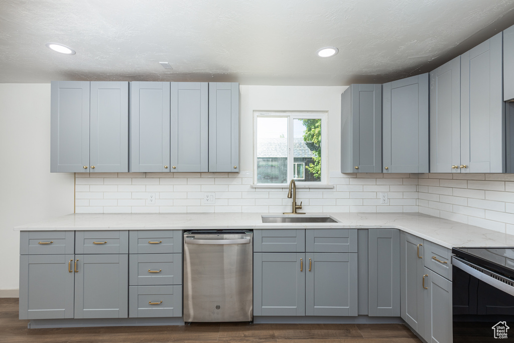 Kitchen with stainless steel dishwasher, a sink, dark wood-type flooring, range with electric cooktop, and gray cabinets