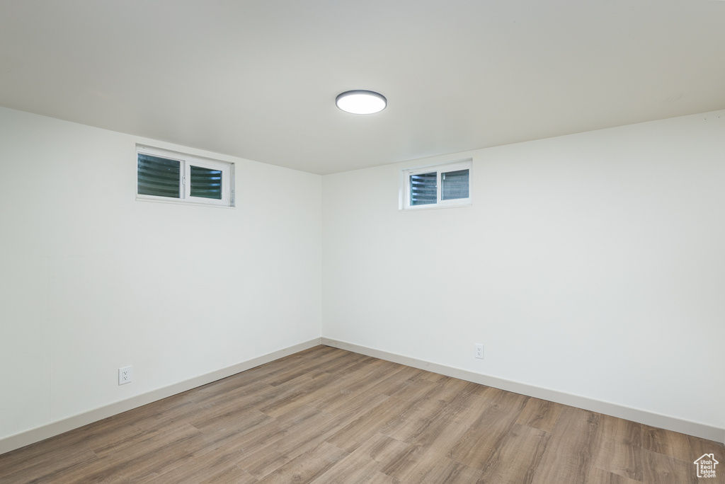 Finished below grade area with light wood-style flooring and baseboards