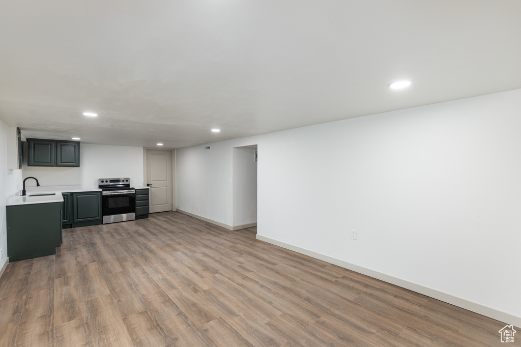 Living area with recessed lighting, wood finished floors, and baseboards