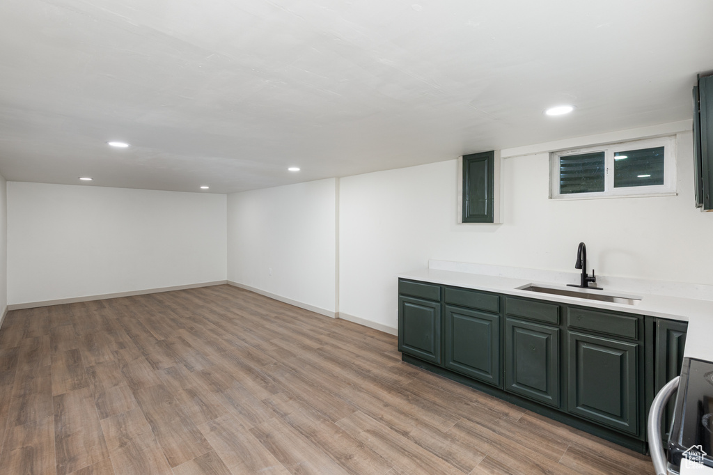 Bar with a sink, light wood finished floors, black range with electric cooktop, recessed lighting, and baseboards