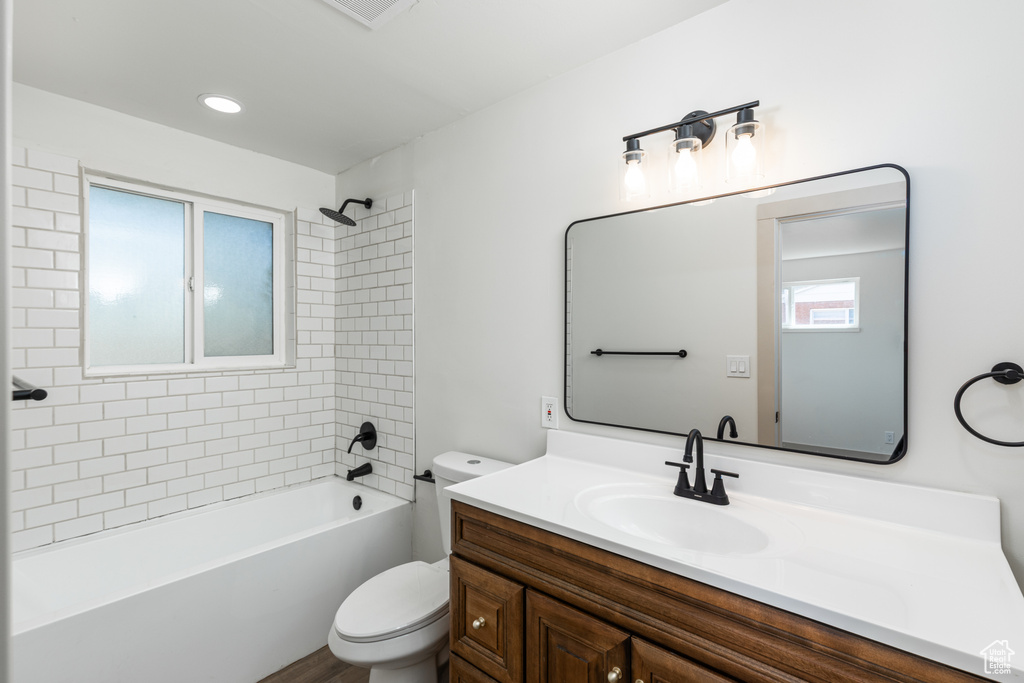Full bath featuring toilet, vanity, shower / tub combination, and wood finished floors