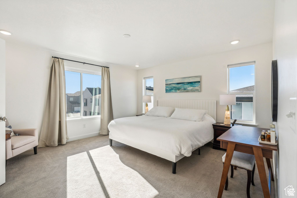 Bedroom with light colored carpet and recessed lighting