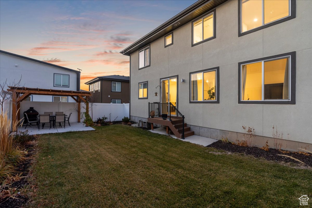 Back of house featuring a patio, a pergola, and stucco siding