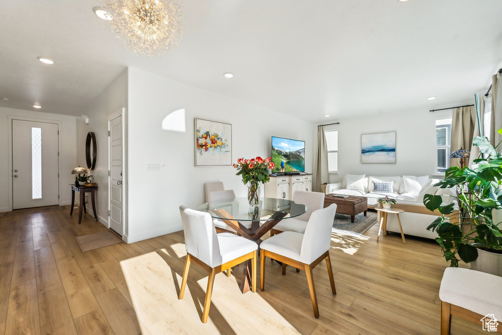 Dining space with a chandelier, light wood finished floors, recessed lighting, and baseboards