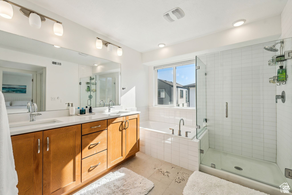 Bathroom with a garden tub, a stall shower, double vanity, and tile patterned floors