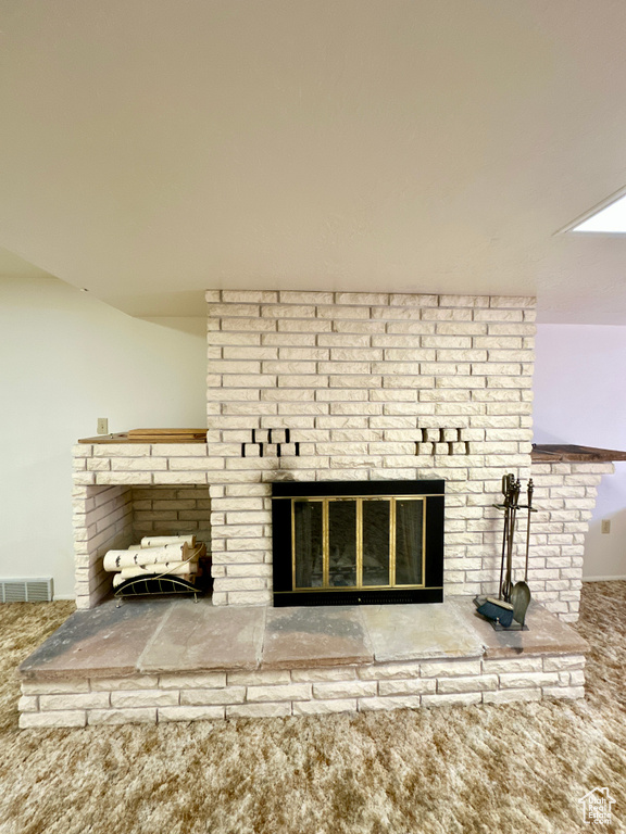 Detailed view of carpet and a brick fireplace