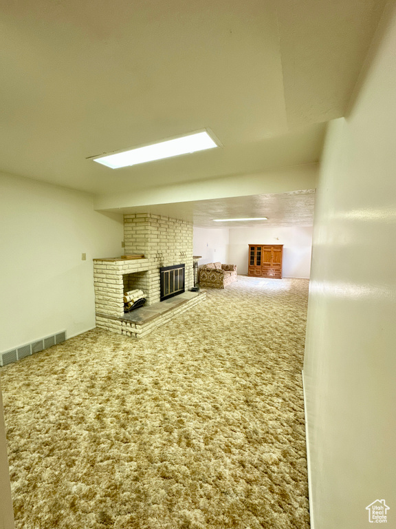 Unfurnished living room with a fireplace and carpet flooring