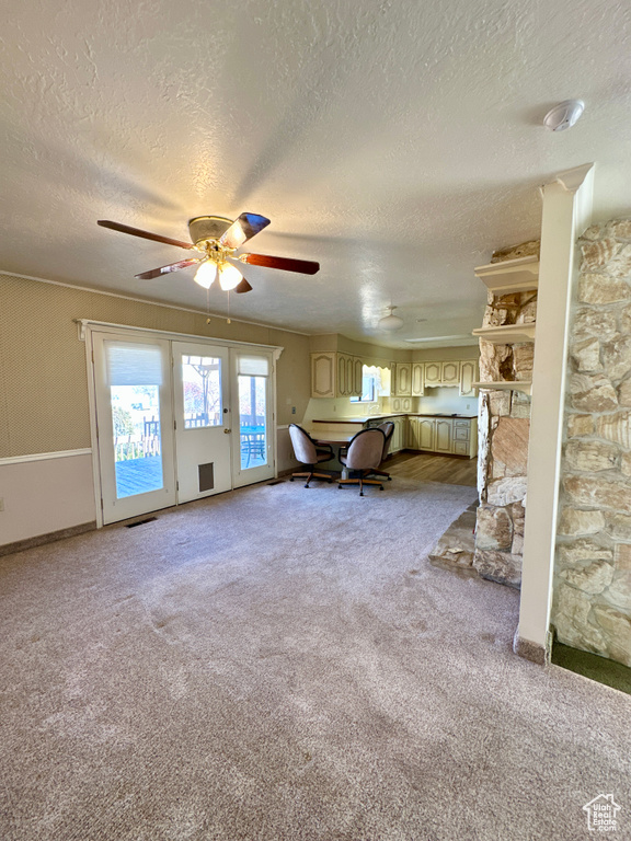 Bedroom with access to outside, a textured ceiling, light colored carpet, and a ceiling fan