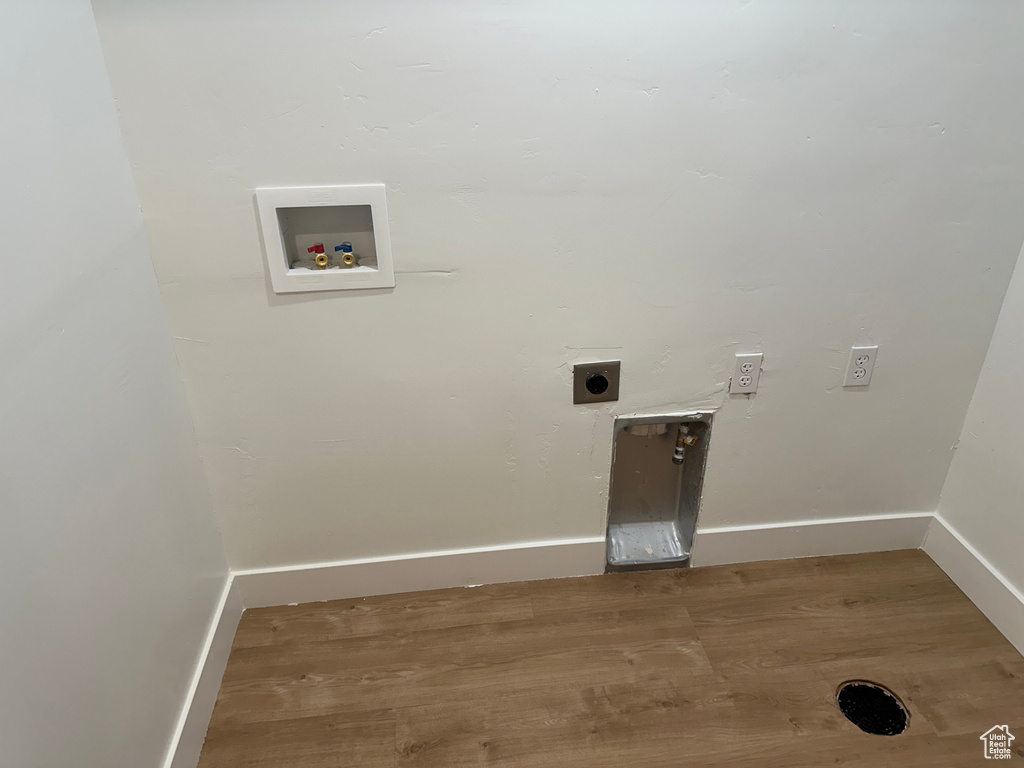 Clothes washing area featuring electric dryer hookup, hookup for a washing machine, baseboards, and wood finished floors