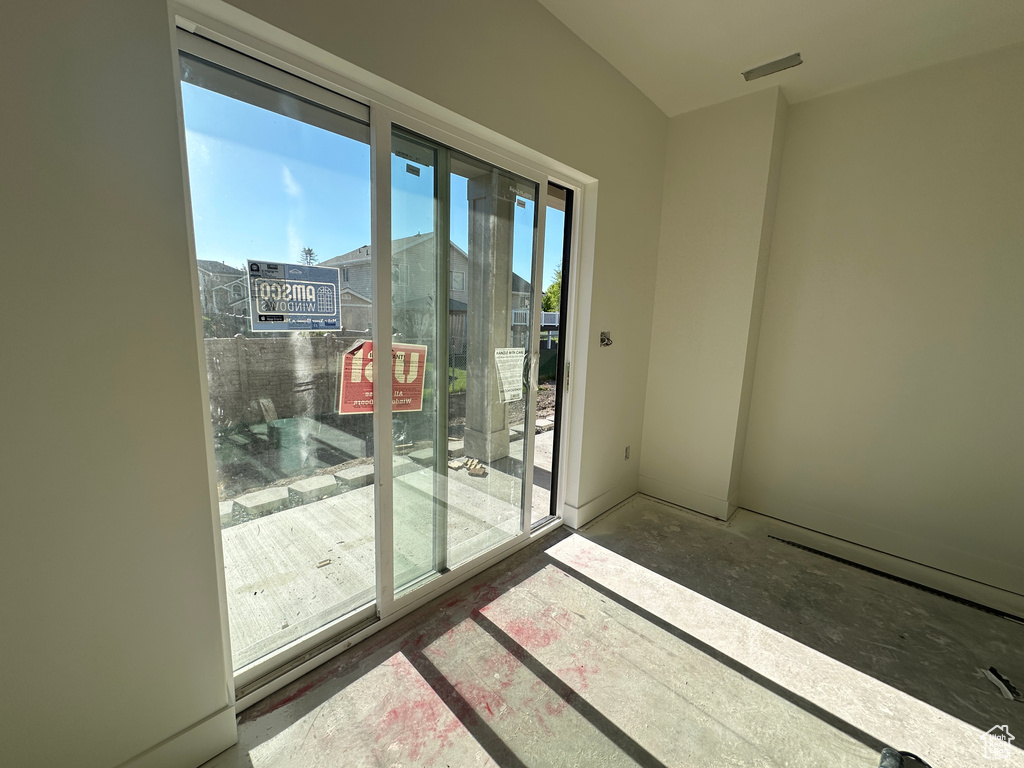 Doorway to outside featuring unfinished concrete flooring