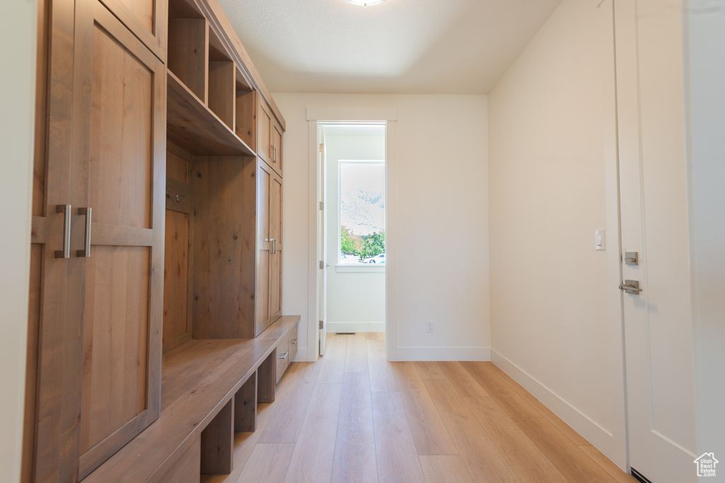 Mudroom with light wood-style flooring and baseboards