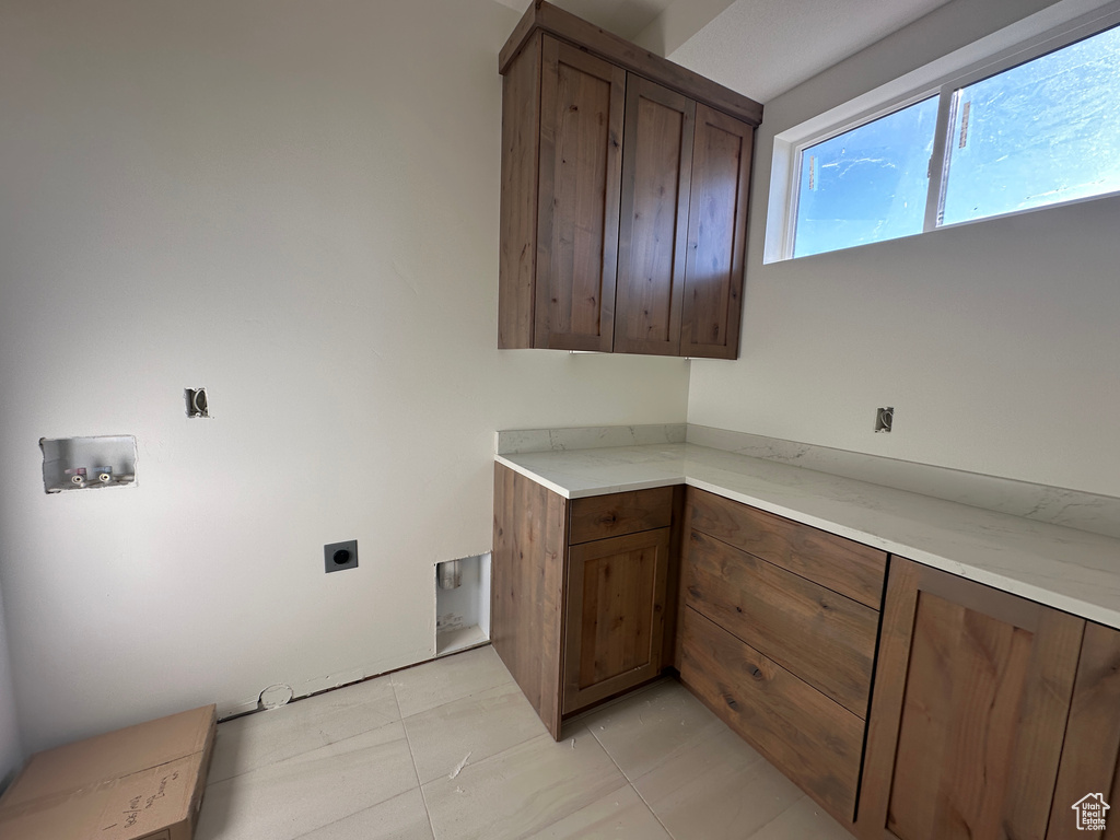 Laundry area with cabinet space, electric dryer hookup, and hookup for a washing machine