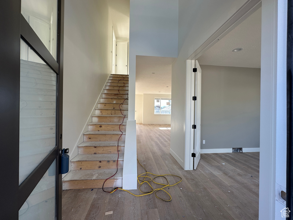 Stairway featuring wood finished floors and baseboards