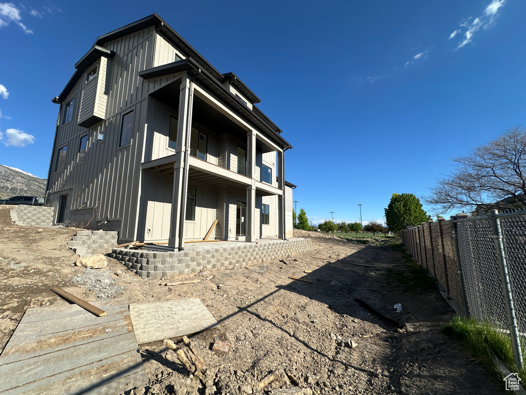 Back of property featuring board and batten siding and fence