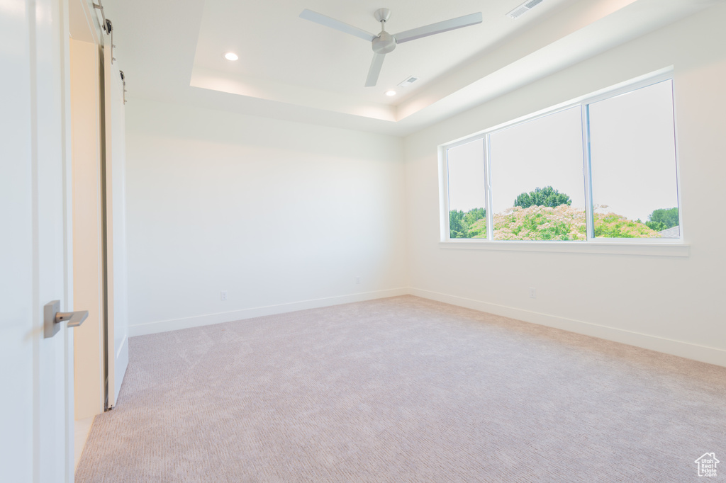 Unfurnished room with recessed lighting, light colored carpet, a tray ceiling, and ceiling fan