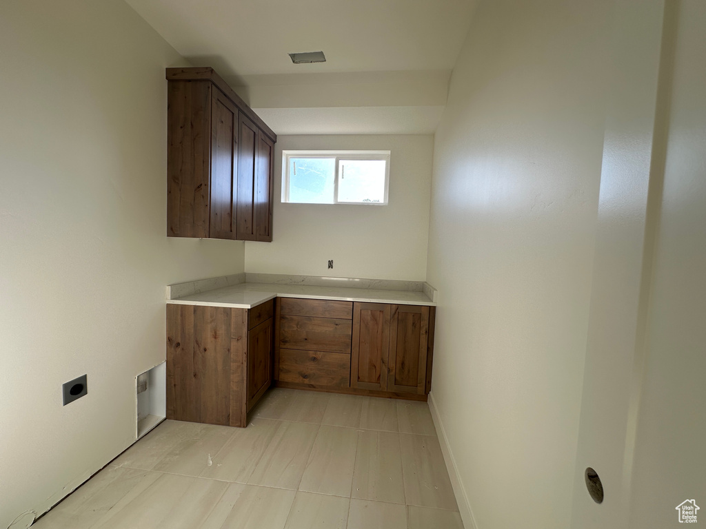 Kitchen featuring light countertops, light tile patterned floors, and baseboards