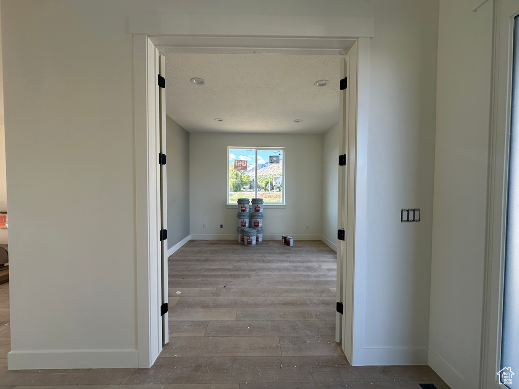 Hall featuring hardwood / wood-style floors and baseboards