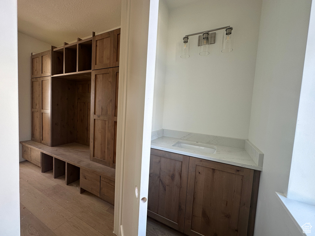 Mudroom with wood finished floors and a textured ceiling