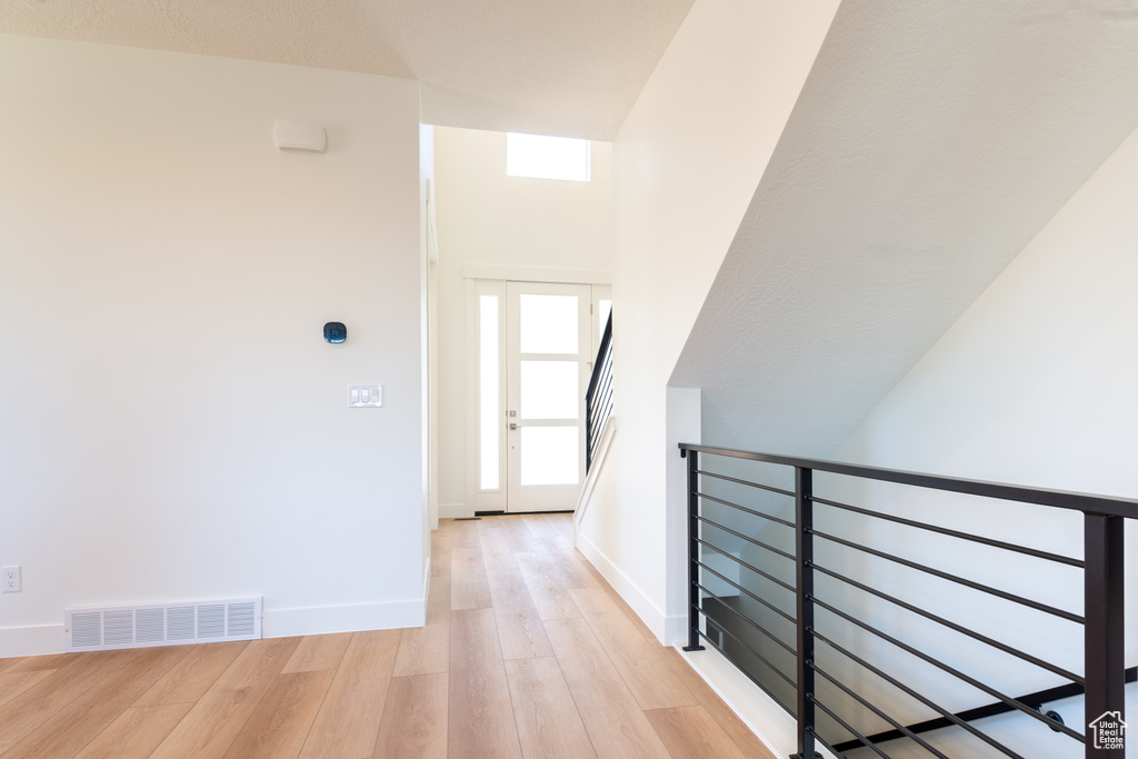 Hall with light wood-style floors and baseboards