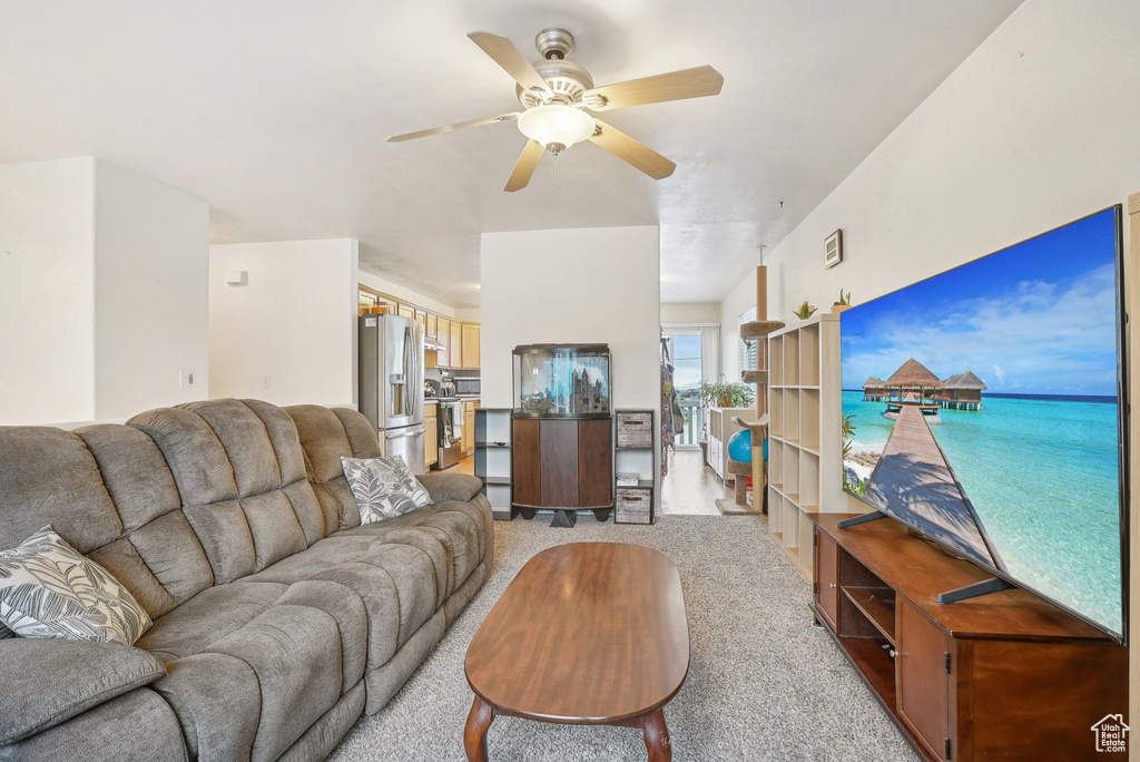 Living room featuring light colored carpet and a ceiling fan