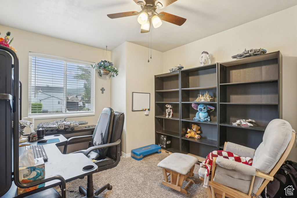 Carpeted office featuring a ceiling fan and baseboards