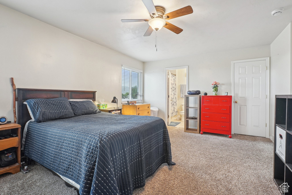 Carpeted bedroom featuring ceiling fan and ensuite bathroom