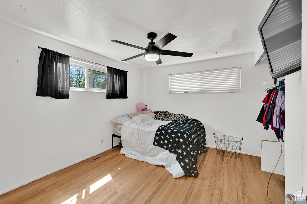Bedroom with wood finished floors, baseboards, and a ceiling fan