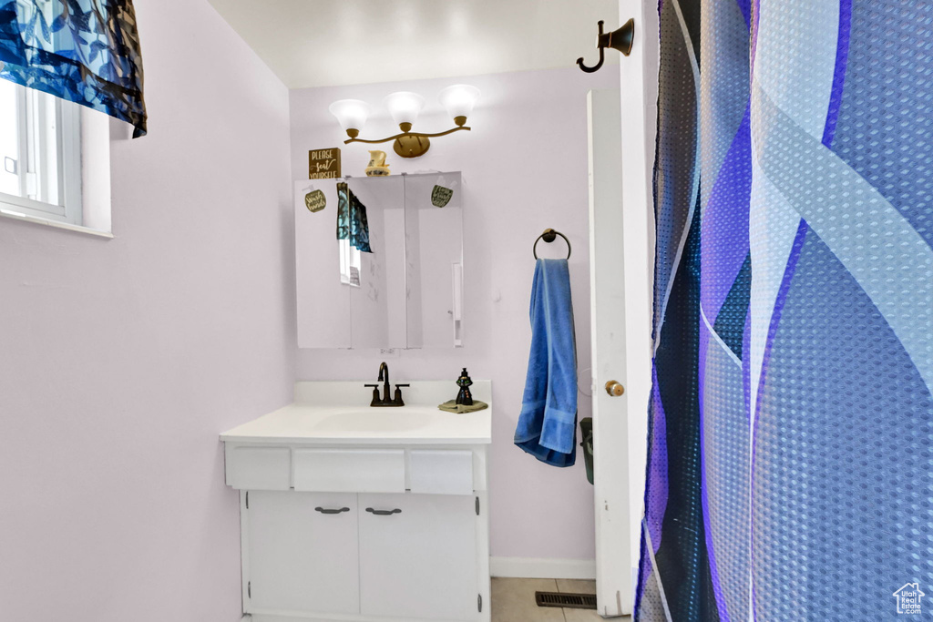 Full bathroom with vanity, tile patterned flooring, a shower, and baseboards