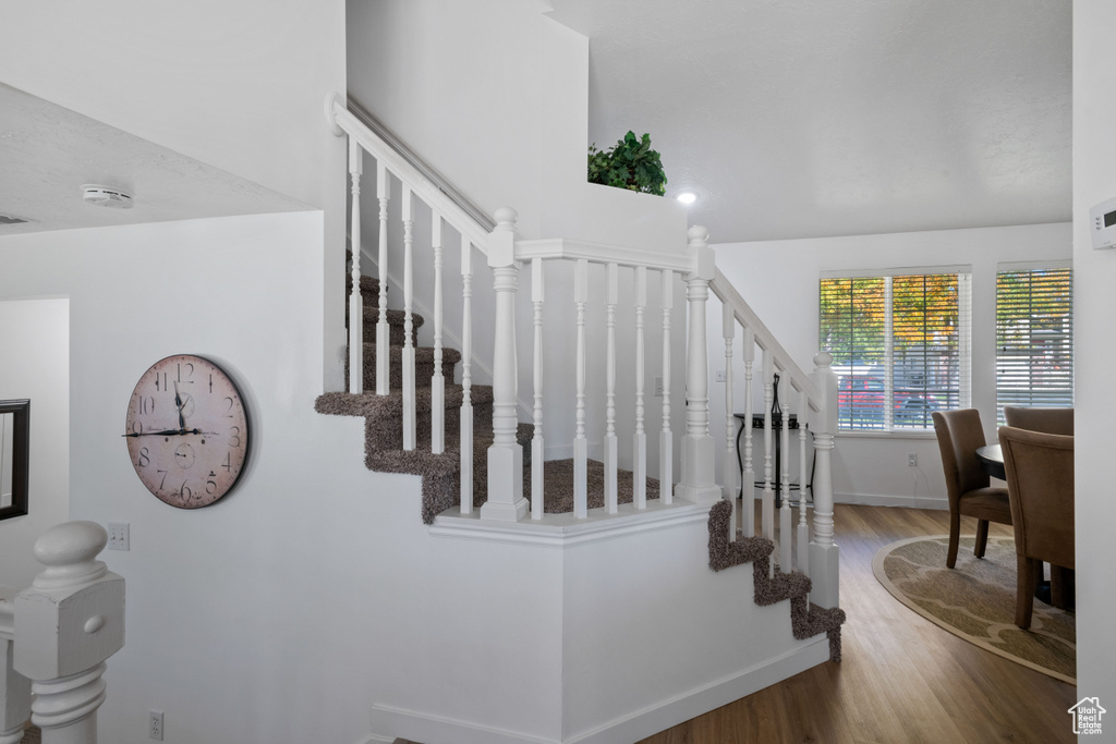 Stairway with wood finished floors and baseboards