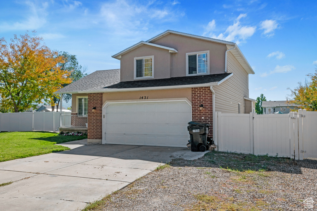 Traditional home with brick siding, driveway, an attached garage, and roof with shingles