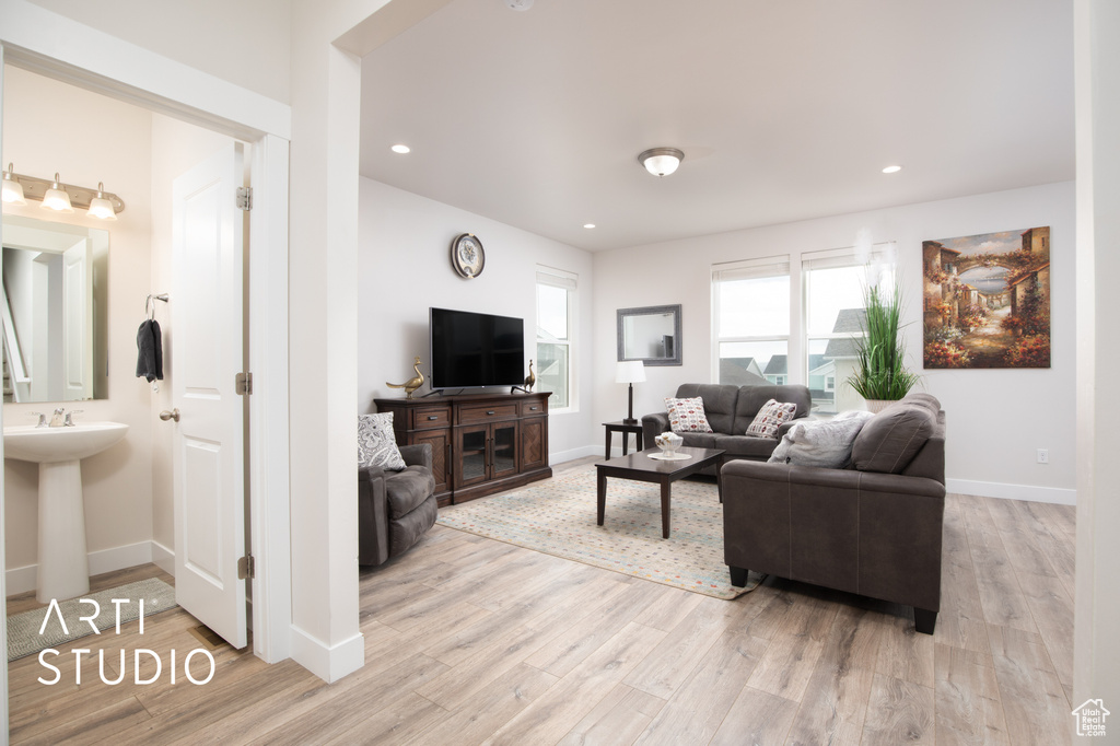 Living room with light wood-style flooring, baseboards, and recessed lighting