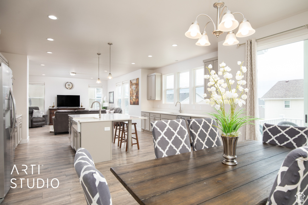 Dining area with light wood finished floors, recessed lighting, and a chandelier