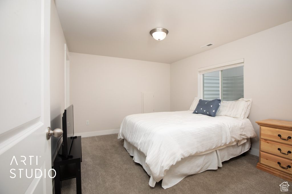 Bedroom featuring carpet and baseboards
