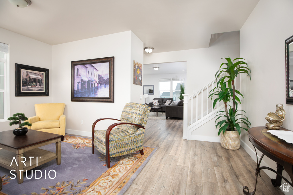 Sitting room with wood finished floors, stairs, and baseboards