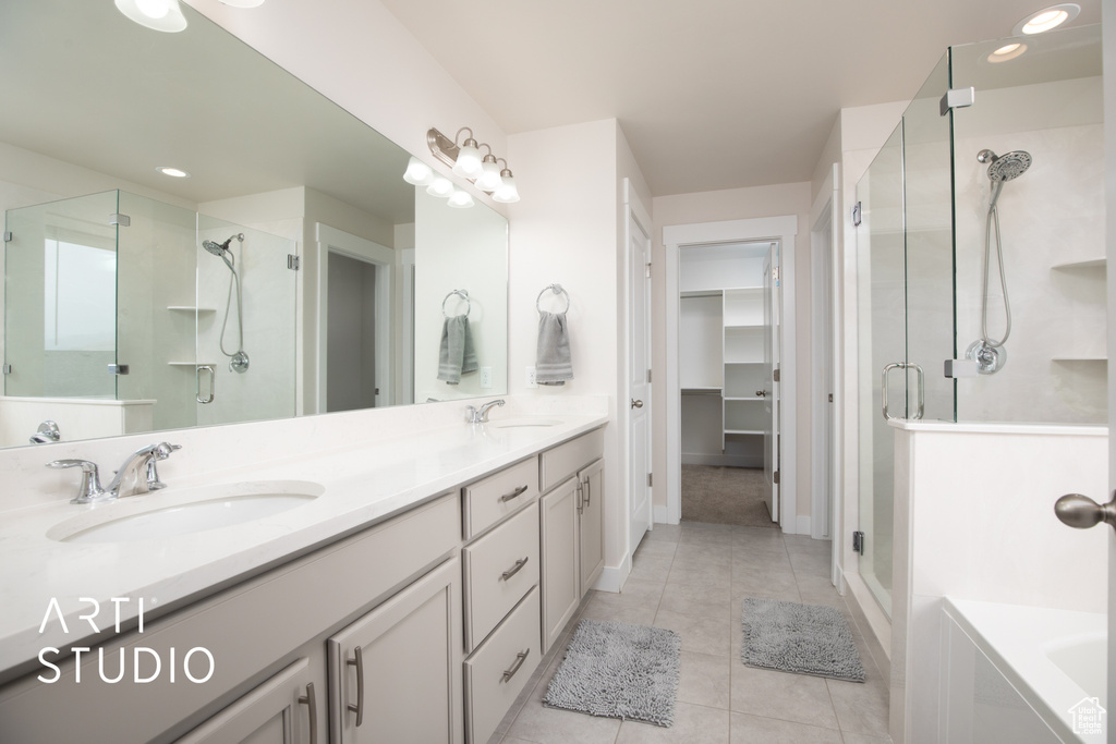 Full bathroom with a stall shower, tile patterned flooring, double vanity, a spacious closet, and recessed lighting