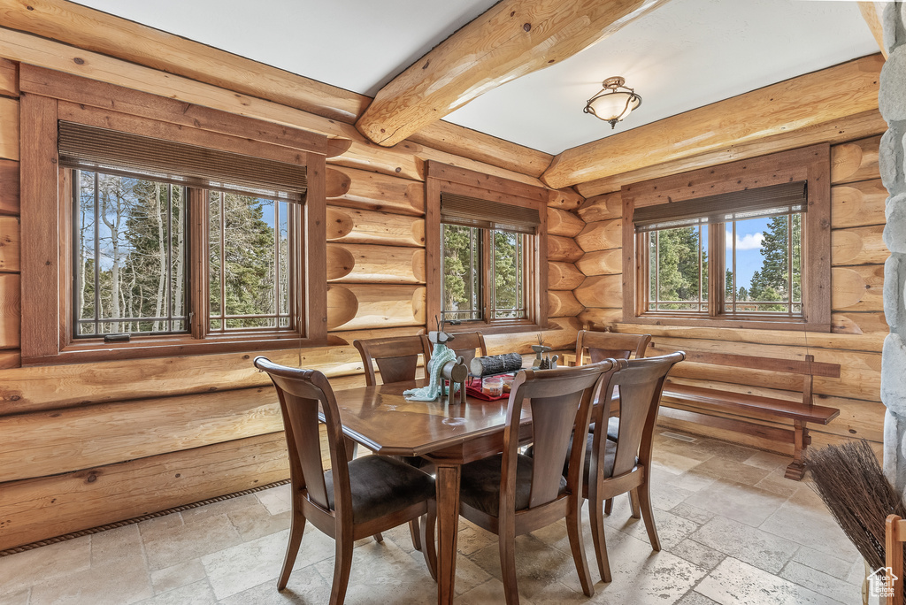 Dining area with beam ceiling and stone tile floors