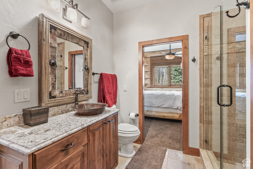 Full bath featuring toilet, a ceiling fan, a shower stall, ensuite bath, and vanity