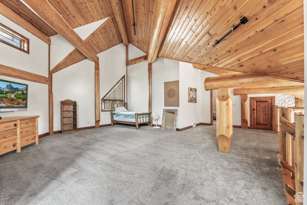 Additional living space with baseboards, vaulted ceiling with beams, wooden ceiling, and carpet