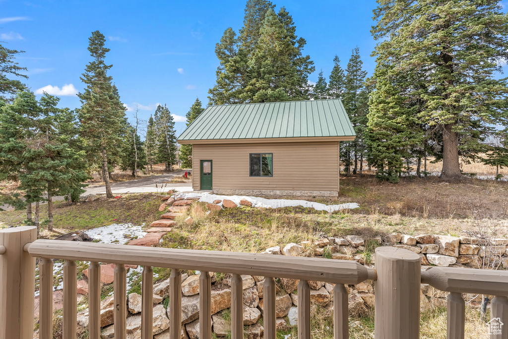 View of property exterior featuring metal roof and an outdoor structure