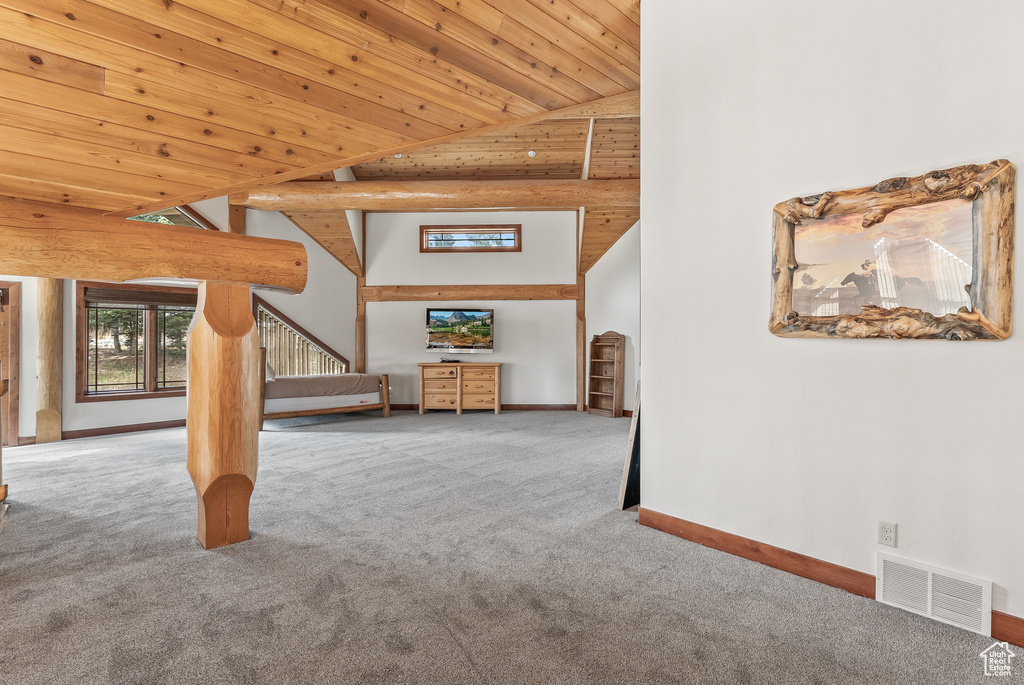 Unfurnished living room with carpet, high vaulted ceiling, visible vents, wooden ceiling, and baseboards