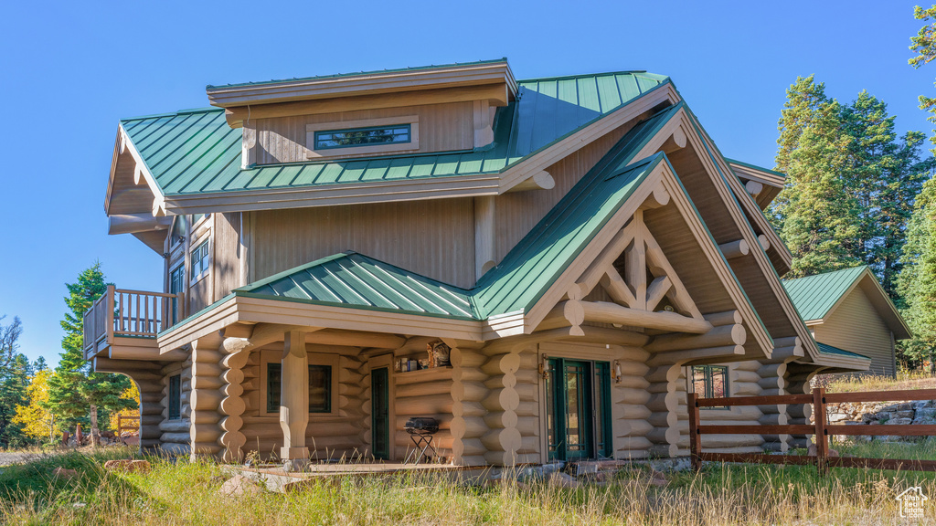 Rear view of property featuring log siding, metal roof, and a standing seam roof