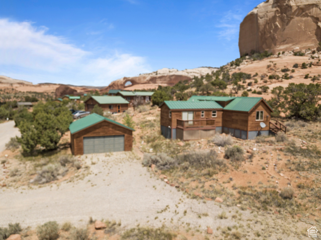 View of front facade with a detached garage, a mountain view, an outdoor structure, and a desert view