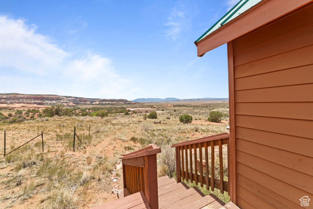 Deck with a mountain view, fence, view of desert, and a rural view