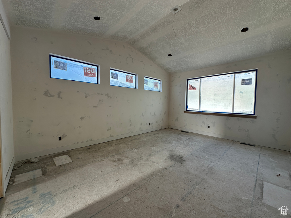 Spare room with lofted ceiling and a textured ceiling