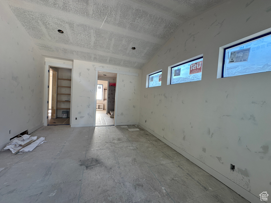 Spare room with vaulted ceiling and a textured ceiling