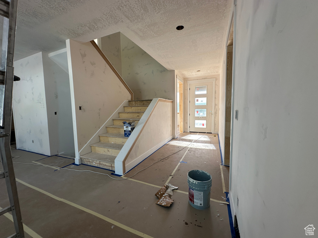 Stairs featuring a textured ceiling