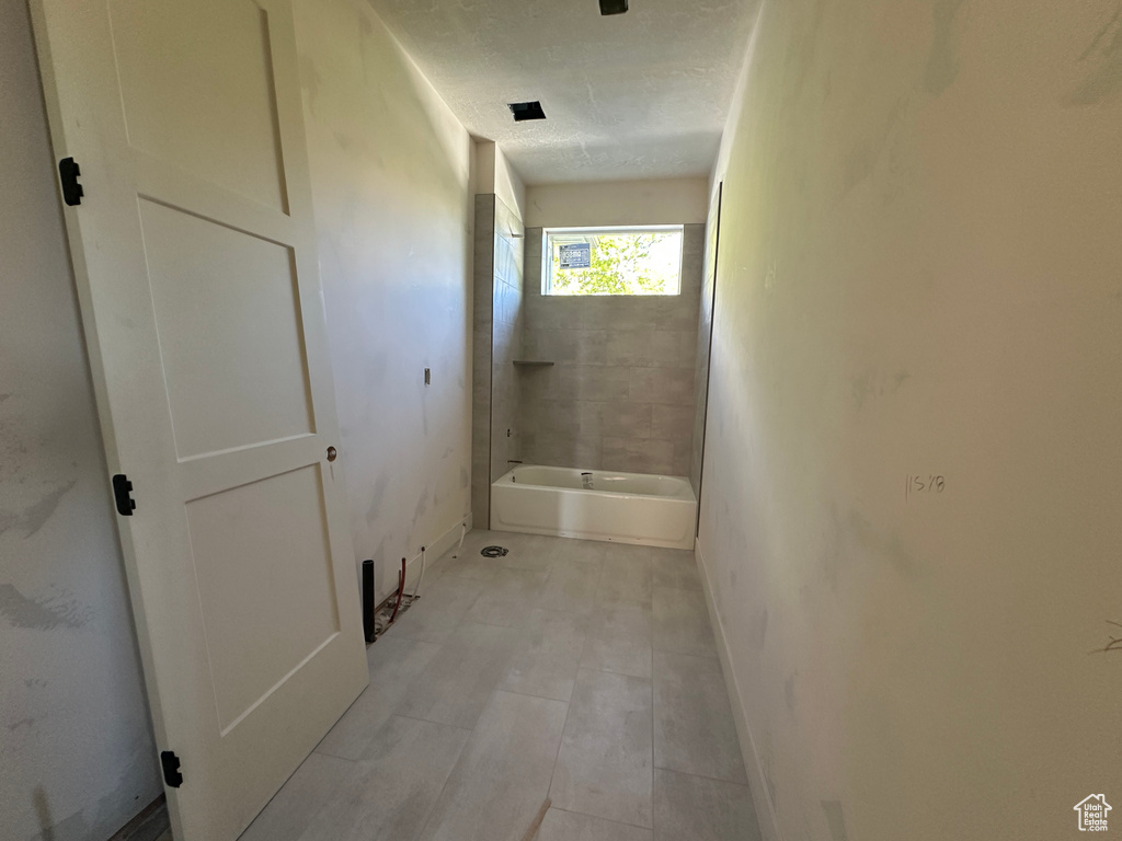 Full bathroom with baseboards and bathing tub / shower combination