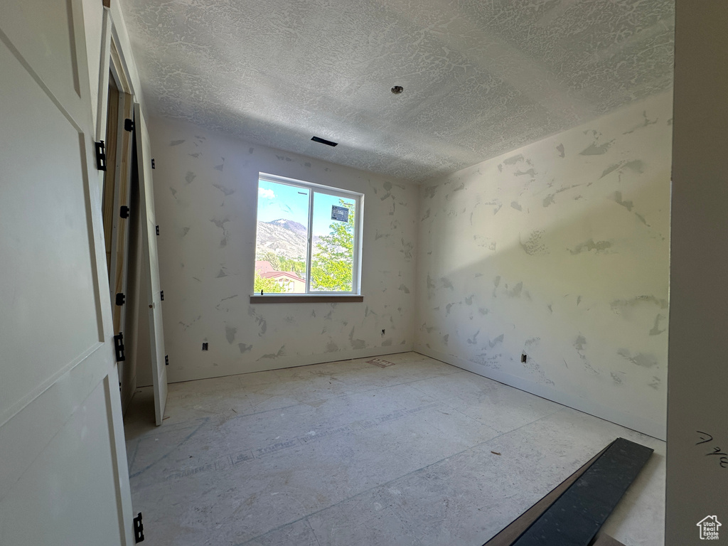 Unfurnished room with a textured ceiling