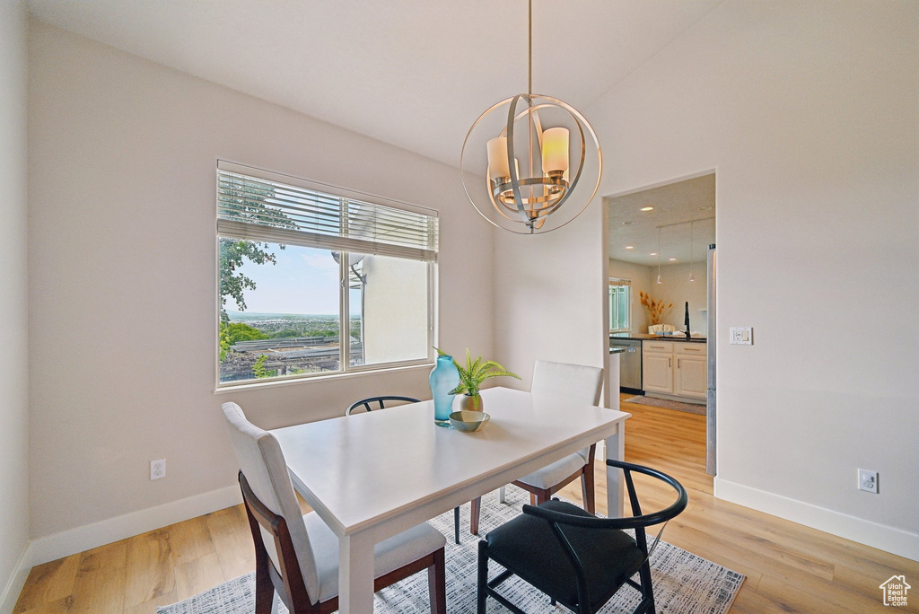 Dining space with a chandelier, baseboards, light wood finished floors, and recessed lighting