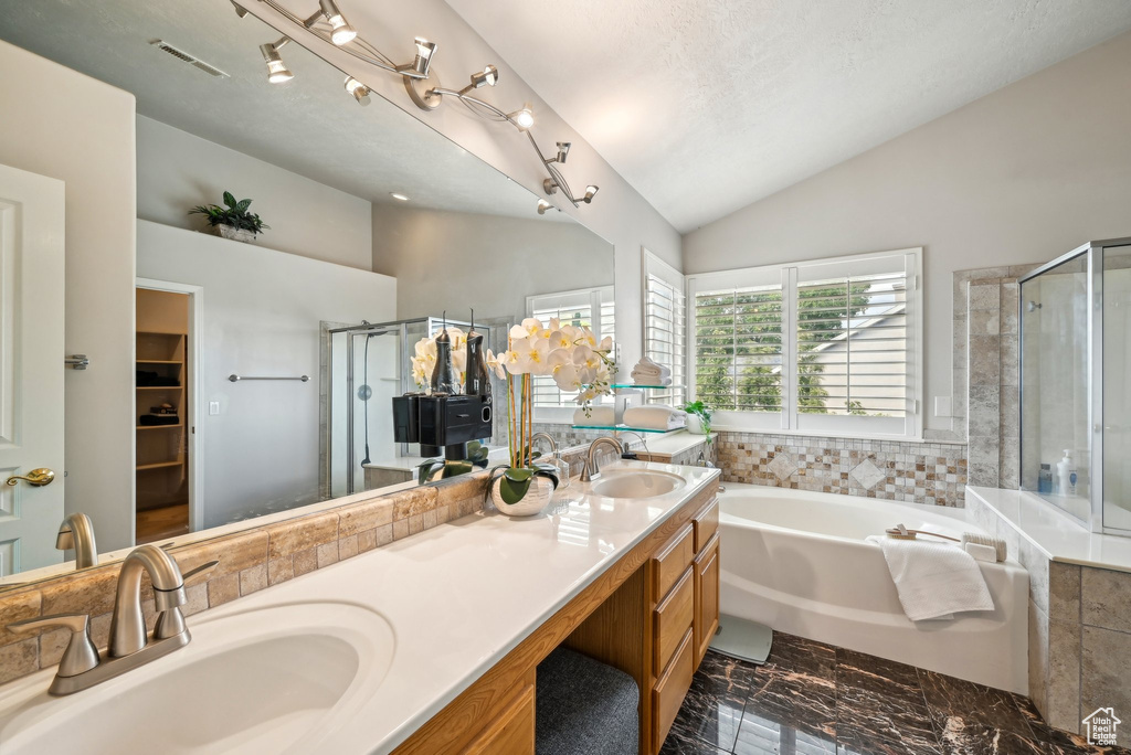 Full bath with lofted ceiling, a stall shower, a garden tub, marble finish flooring, and double vanity